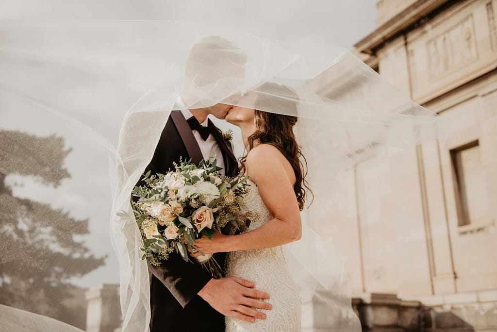 What a $20K Wedding Budget Looks Like in Lafayette, Baton Rouge, New Orleans & Lake Charles 1 $20k Wedding Budget In Lafayette Louisiana Wedding Photography Bride and Groom Kissing beneath veil holding bouquet