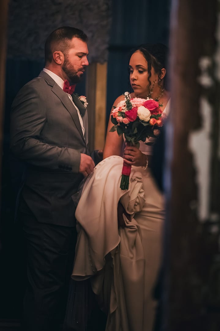 Bride holding her bouquet with her father by her side moments before walking down the aisle – captured in a quiet, emotional pause with cinematic lighting